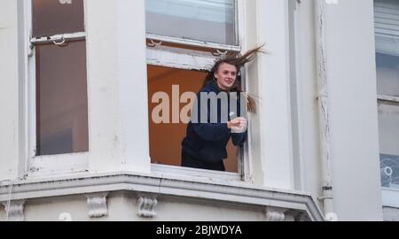 Brighton UK 30th April 2020 - Residents in Kemp Town Brighton take part in the  Clap For Our Carers as they applaud NHS staff and key workers on a windy evening as the country thanks them for their efforts in the battle against coronavirus COVID-19   : Credit Simon Dack / Alamy Live News Stock Photo