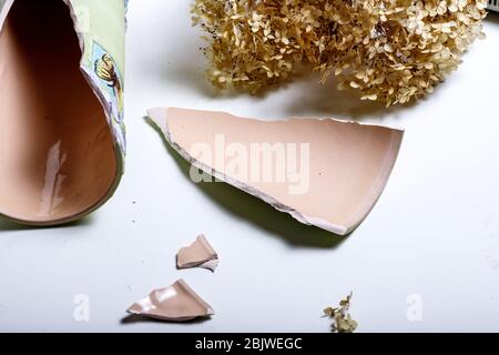 An old broken colored jug of clay lies on dry soil on the ground in Sicily Stock Photo
