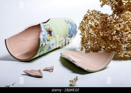 An old broken colored jug of clay lies on dry soil on the ground in Sicily Stock Photo