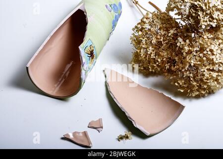 An old broken colored jug of clay lies on dry soil on the ground in Sicily Stock Photo