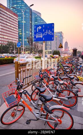 Beijing / China - October 12, 2018: Mobike bicycle-sharing system bicycles parked on a sidewalk along the Changan Avenue in downtown Beijing, China Stock Photo