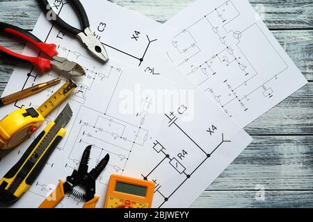 Different electrical tools and circuit diagram on wooden background Stock Photo
