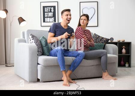 Young couple having conflict while playing video game at home Stock Photo