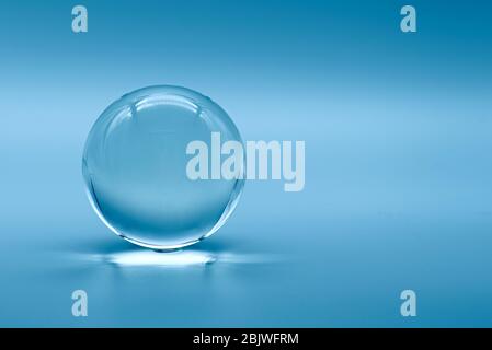 Glass ball on blue background, glass globe ball Stock Photo