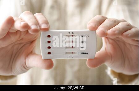 Woman holding test for HIV, Hepatitis B, C and Syphilis, closeup Stock Photo