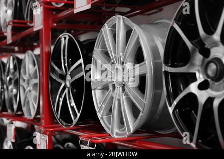 Stand with alloy wheels in modern tire store Stock Photo