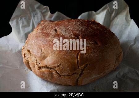 Home made sourdough bread on baking paper. Organic food. Whole grain rye flour. Stock Photo