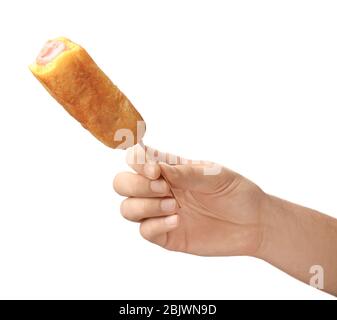 Woman holding tasty corn dog on white background Stock Photo