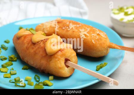 Tasty corn dogs with mustard on plate, closeup Stock Photo