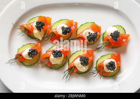 Delicious canapes with black caviar on plate Stock Photo