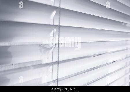 Modern white blinds on window, closeup Stock Photo