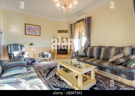 Large cozy bedroom in classic style, beige furniture, rugs and mirrors. Stock Photo