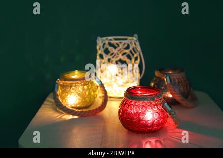 Burning candles in glass holders on table Stock Photo