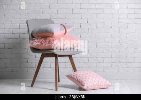 Different pillows on chair in room Stock Photo