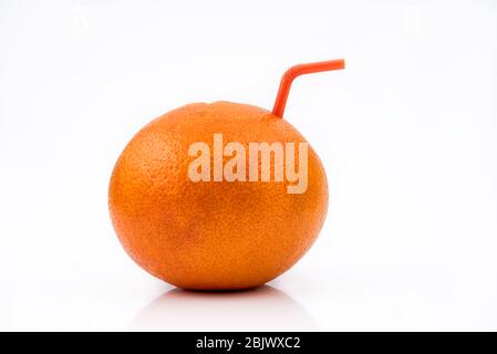 Isolated Grapefruit juice. A whole Red Grapefruit with orange straw, concept of natural fresh fruit juice isolated on white background Stock Photo