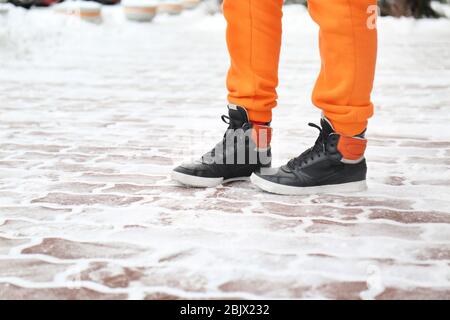 Stylish woman wearing warm shoes on city street in winter Stock Photo