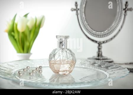 Tray with bottle of perfume on table Stock Photo