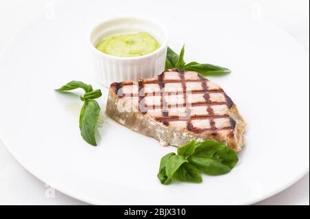 Steak with sauce and basil on a white plate Stock Photo