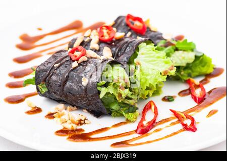 Raw vegan nori hand rolls with sauce, salad and vegetables. Vegetarian, gluten-free food.