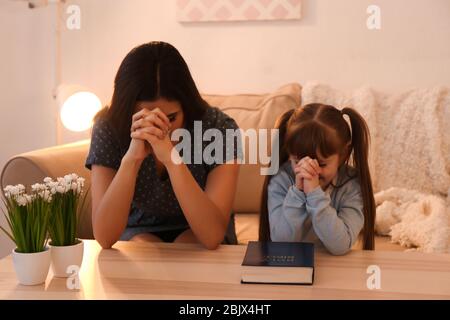 Religious Christian girl and her mother praying at home Stock Photo