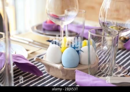 Stand with colorful eggs for Easter table setting Stock Photo