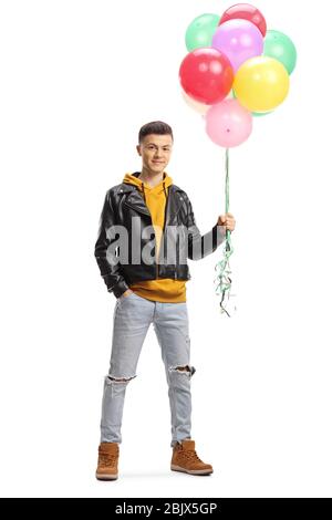Full length portrait of a guy smiling and holding a bunch of colorful balloons isolated on white background Stock Photo