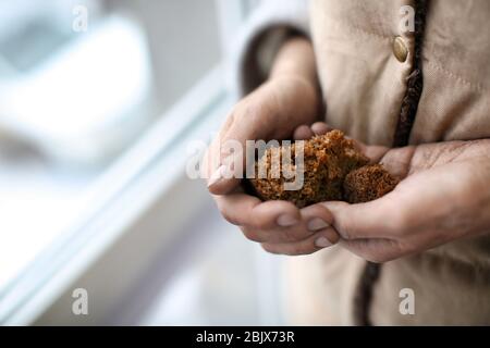Poor woman holding bread on blurred background Stock Photo
