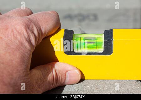 Close up of hand with spirit level Stock Photo