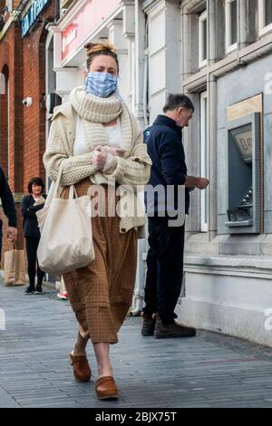 Clonakilty, West Cork, Ireland. 30th Apr, 2020. A woman Walks down Clonakilty Main Street wearing a face mask to protect herself from Covid-19. Credit: AG News/Alamy Live News Stock Photo