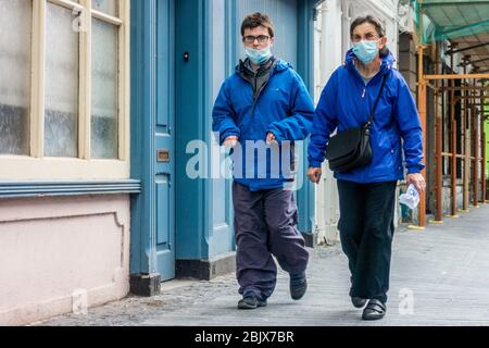 Clonakilty, West Cork, Ireland. 30th Apr, 2020. A man and woman walk down Clonakilty Main Street wearing face masks to protect themselves from Covid-19. Credit: AG News/Alamy Live News Stock Photo