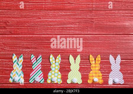 Easter bunnies made from patterned paper on wooden background Stock Photo