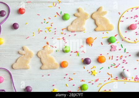 Raw bunny shaped cookies, sprinkles and candies on table Stock Photo