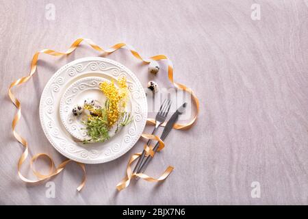 Beautiful festive Easter table setting with mimosa and quail eggs Stock Photo