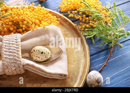 Beautiful festive Easter table setting with mimosa and quail eggs, closeup Stock Photo