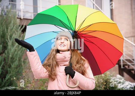 Young woman with rainbow umbrella outdoors Stock Photo
