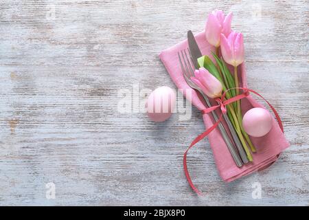 Beautifully decorated cutlery and eggs for Easter table setting on wooden background Stock Photo