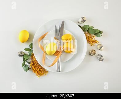 Beautiful festive Easter table setting with mimosa and eggs on white background Stock Photo