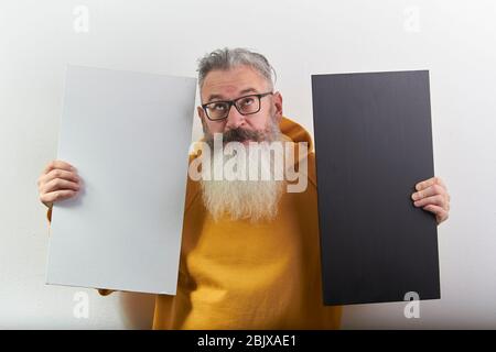 Portrait of mature gray-haired bearded man with white and black sheet over isolated white background, selective focus Stock Photo