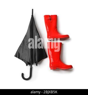 Black umbrella and gumboots on white background Stock Photo
