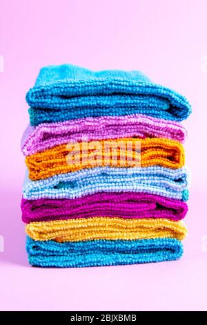 Multi-colored towels on a pink background. Pink, beige, yellow, orange and blue towels. House order Stock Photo