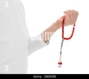 Young Muslim man with prayer beads making tasbih on white background Stock Photo