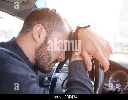 Young man sleeping in car during traffic jam Stock Photo