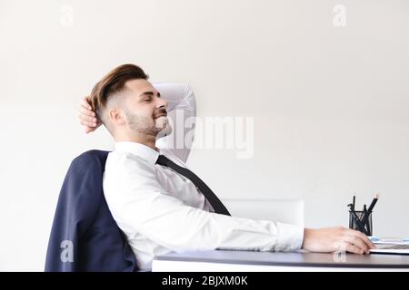 Handsome businessman having break during work in office Stock Photo