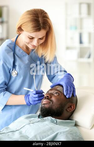 Plastic surgeon applying marks on patient's face in clinic Stock Photo