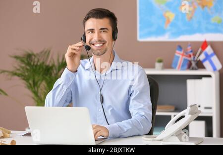 Male travel agent working in office Stock Photo