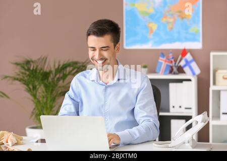 Male travel agent working in office Stock Photo