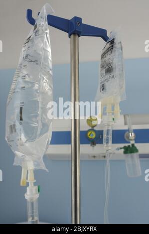 woman stretched out in a hospital bed, connected with different routes to intravenous medications. Stock Photo