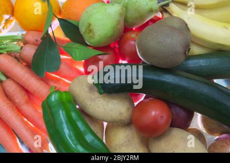 A flat lay of a table full of fruits and vegetables such as: potatoes, zucchini, carrots, bell peppers, kiwis. All lit from behind creating a unique e Stock Photo