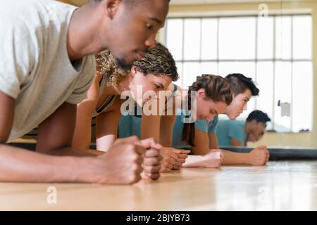 Group of friends doing planks in exercise classÂ Stock Photo