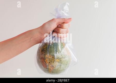 Hand holding earth globe in plastic bag Stock Photo
